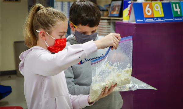 Two students compare bags of salt dough